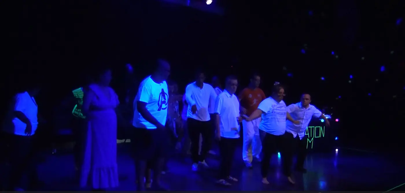 Le groupe d’interprètes réuni sur le plateau, dans une lumière bleue.
